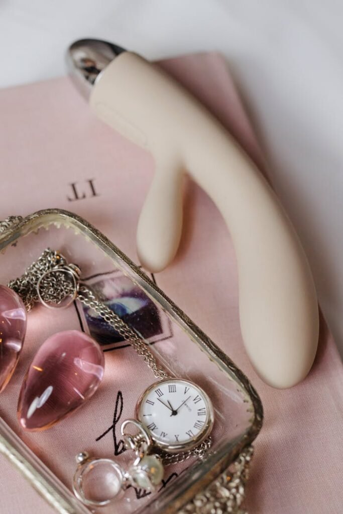9u09 Stylish flatlay featuring vibrator, rose quartz, and jewelry for a sophisticated sensual aesthetic.